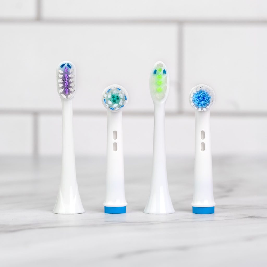 electric toothbrush heads on a marble counter in a bathroom 